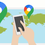 Hands holding a phone with map and Google location pins in the background