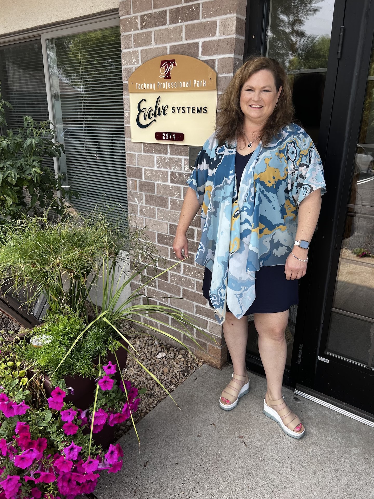 Marnie Ochs-Raleigh posing for a photo outside of the Evolve Systems office